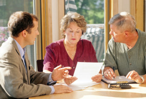 Couple reviewing documents with advisor at table